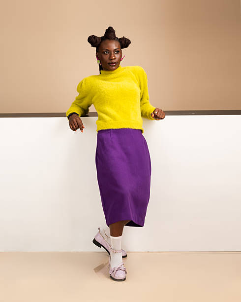 istock Stylish African woman leaning on white wall in studio 2231887621