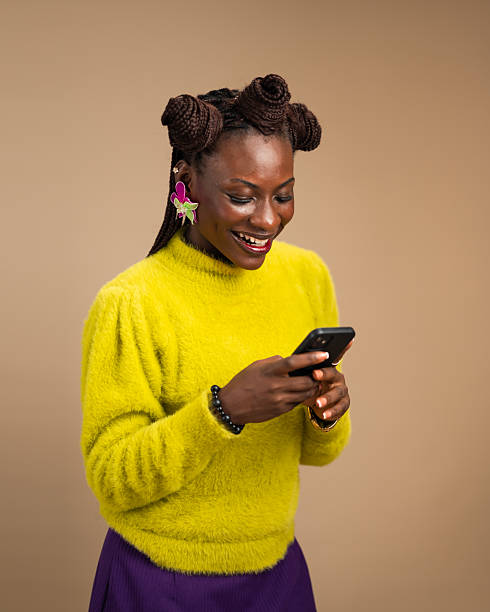 istock Joyful young African woman reading smartphone message in studio 2231888421