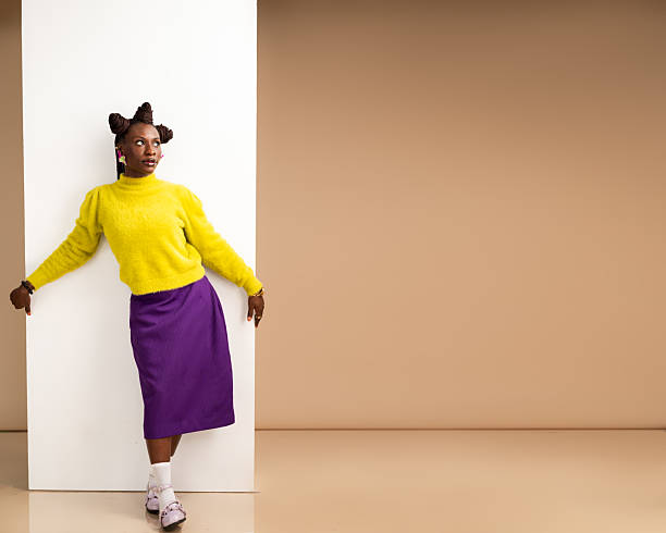 istock African woman standing against wall panel with arms stretched 2231889604