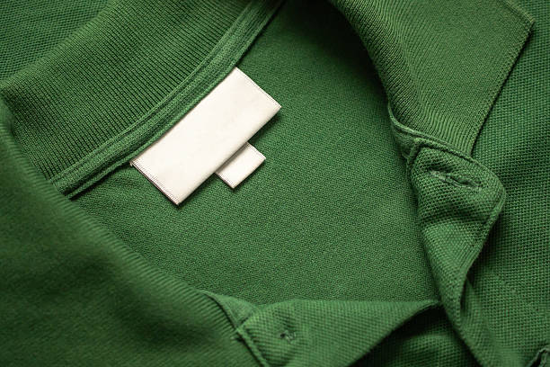 istock Blank white laundry care clothes label on green shirt fabric texture background 2231896010