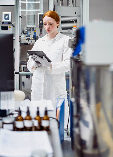 istock Young Caucasian Female Pharmacy Worker in Laboratory Reading Data on Digital Tablet 2231897256