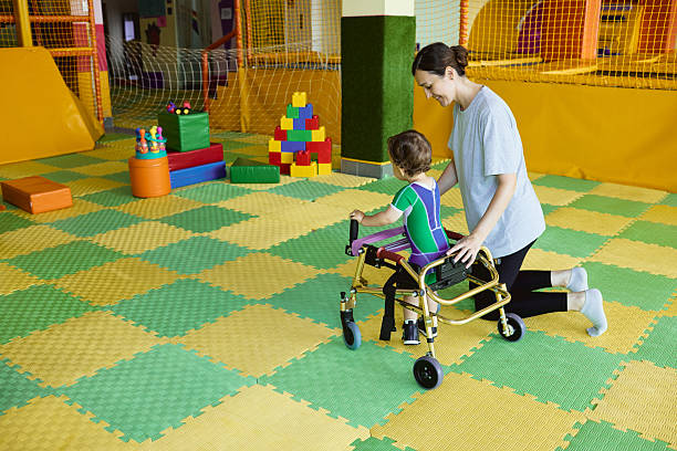 istock Physiotherapist assists young boy with musculoskeletal disorders using mobility aids during rehabilitation exercises in supportive environment 2231901527