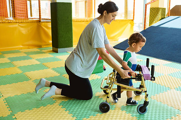 istock Physiotherapist assists a young boy with musculoskeletal disorders using mobility aids during rehabilitation exercises 2231901528