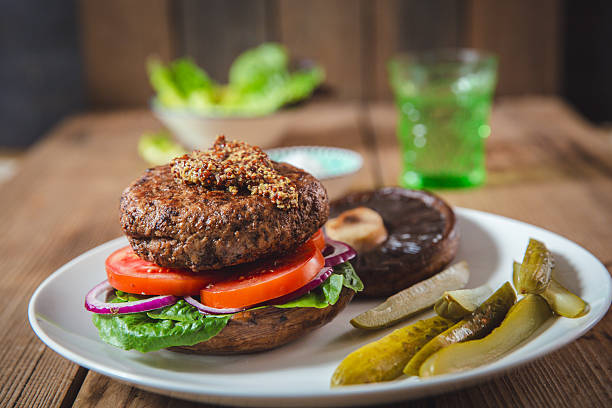 Gourmet Portobello Turkey Burger on Rustic Setting With Pickles and Greens