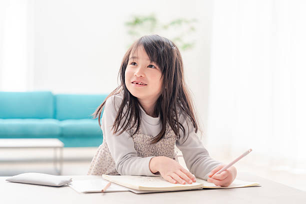 istock Early elementary school girl doing homework alone at home 2231927243