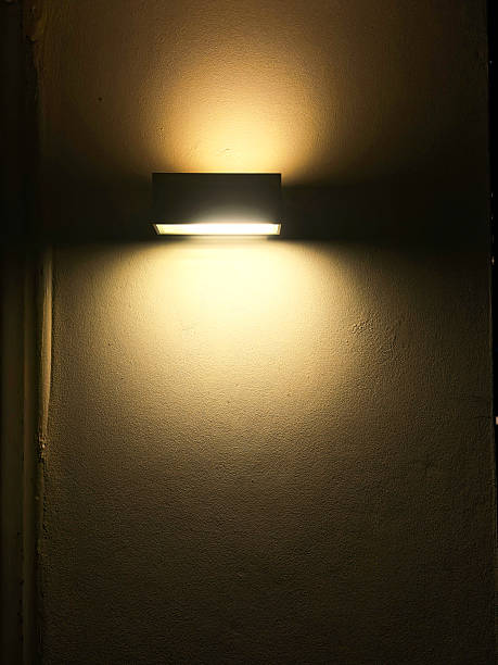 istock Glowing light fixture attached on house exterior wall at night 2231928686