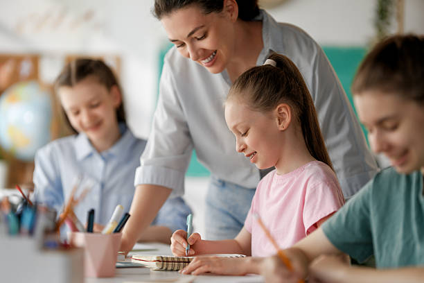 istock Happy kids and teacher at school 2231935791
