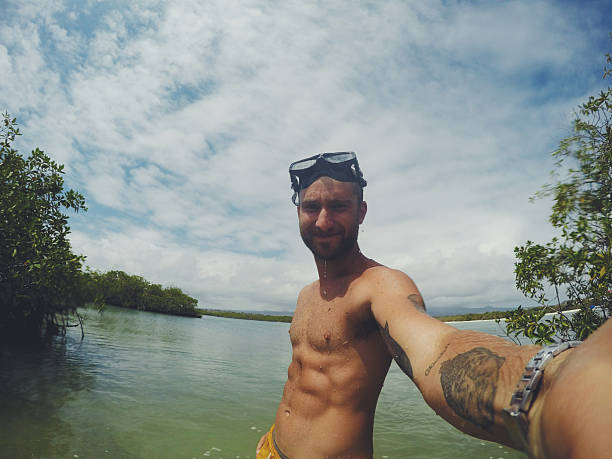 Tourist taking a selfie while snorkeling in a tropical lagoon