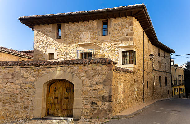 A large stone building with a wooden door. The building is old and has a rustic appearance