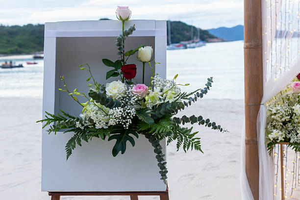 istock Floral arrangement with roses and greenery displayed on beachside backdrop with ocean view 2231938617