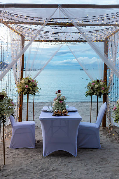 istock Romantic beach wedding setup with elegant table, floral arrangements and ocean view backdrop 2231938625