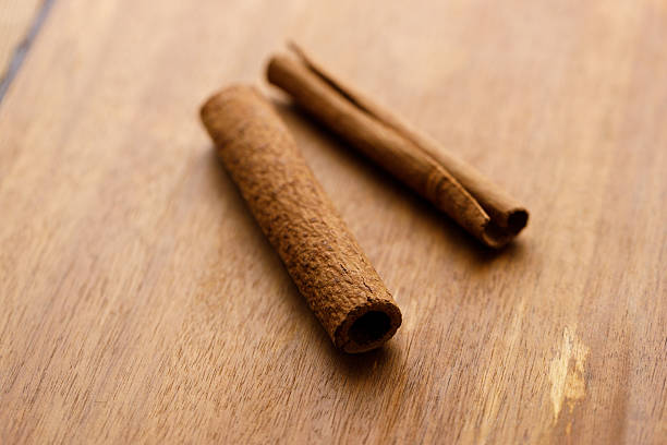 istock Cinnamon sticks dried tree bark spice on rustic wooden table background. 2231940687