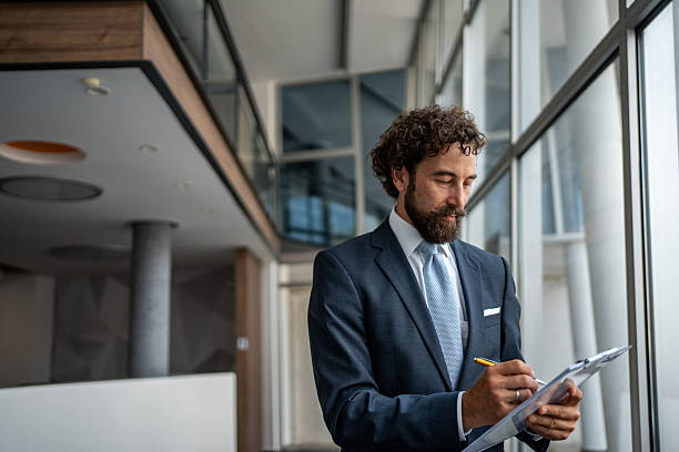 istock Focused businessman working on clipboard in modern office 2231940762