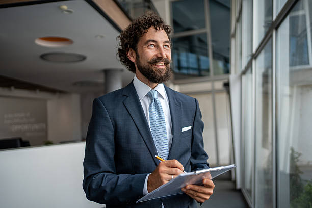 istock Smiling businessman taking notes on clipboard in office 2231940863