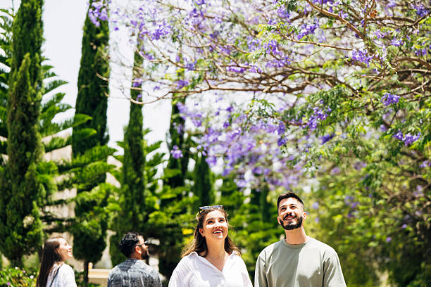 Tourists walking down lush Jacaranda treelined avenue in Abha