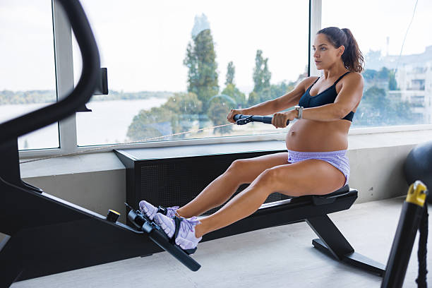 istock Pregnant woman pulling cable on workout equipment in the gym 2231941688