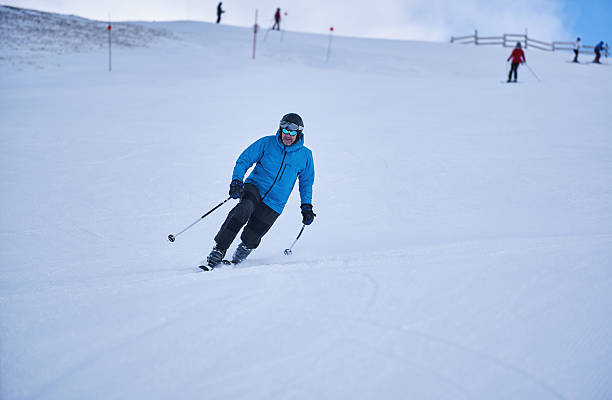 Man skiing telemark style on snowy mountain slope