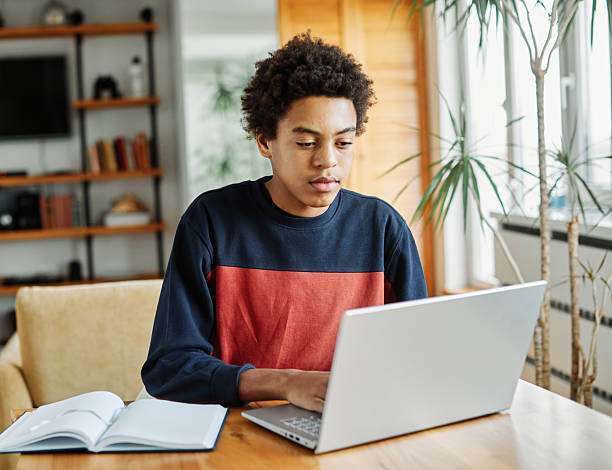 istock education laptop student computer teenager studying boy learning homework study young school teenage black technology happy internet sitting college online man notebook using 2231943355