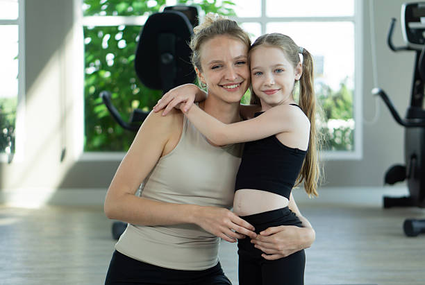 istock Smiling mother and daughter embracing in a bright gym during a fun workout session 2231943997