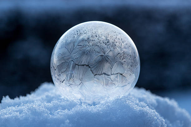 istock Frozen soap bubble in the snow at sunrise, nature background, calm ice structure 2231946387
