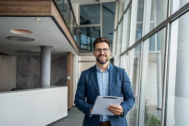 istock Smiling businessman holding clipboard in modern office 2231948911