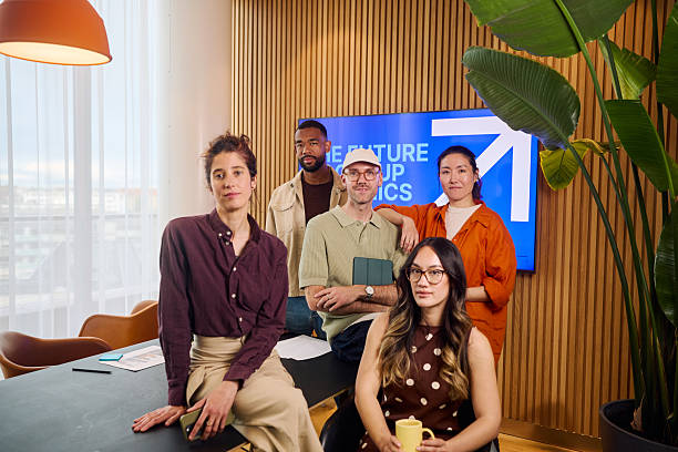 Diverse team of professionals posing together in a modern office space, showcasing teamwork and company culture