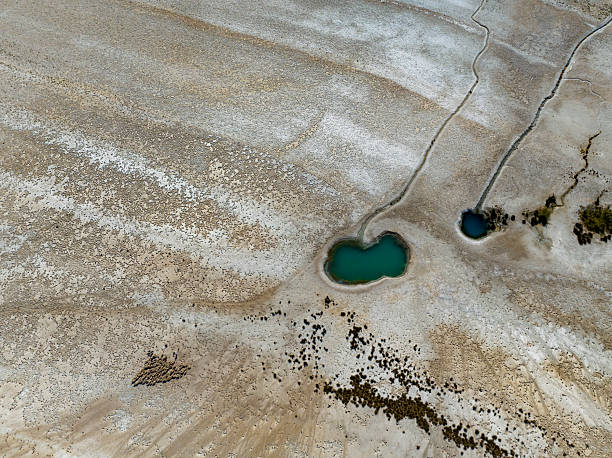 istock NATURAL GROUNDWATER SOURCECracked dry soil and shrinking lakes. PATTERNS emerging in nature, abstract shapes, drought and climate crisis, water scarcity, global warming, and drying soils.DRONE photo 2231952857