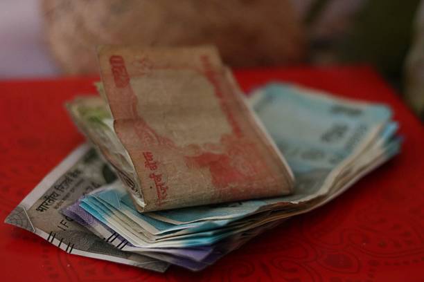 istock Stacked and folded Indian rupee notes on a red background, used as a sacred offering during worship, puja ceremonies, and cultural traditions. 2231953525