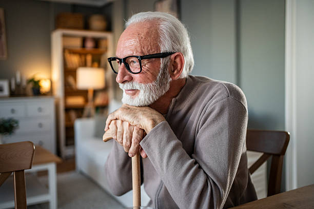 istock Senior man leaning on walking cane and looking away thoughtfully 2231956450