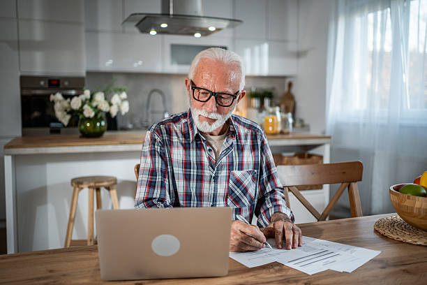istock Senior man managing home finances with laptop and documents 2231957298