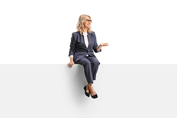 istock Middle aged woman sitting on a blank panel and talking 2231960886