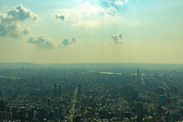 Beautiful atmospheric view over Taipei City with scattered clouds and sun rays streaming down onto the urban landscape in the late afternoon