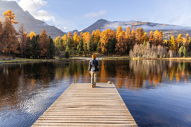 istock Man Standing on Dock Overlooking Autumn Lake 2231961743