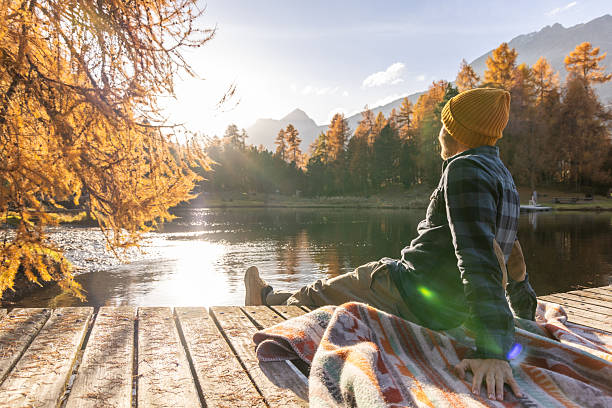 istock Man Relaxing by Lake in Autumn Forest 2231961747
