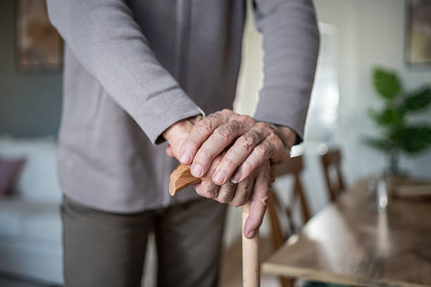istock Senior man holding walking cane at home 2231964293
