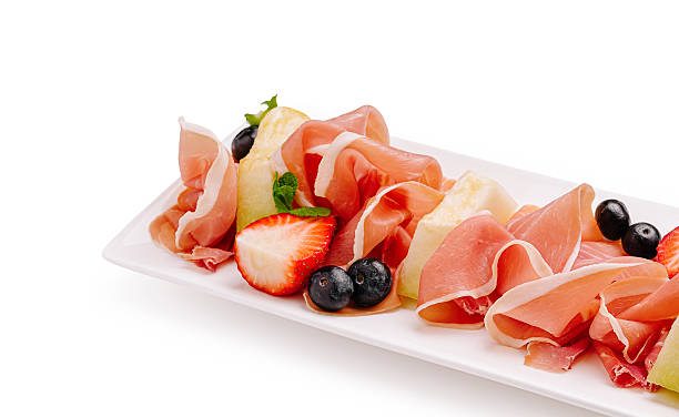 Delicious charcuterie platter featuring prosciutto with berries and mint