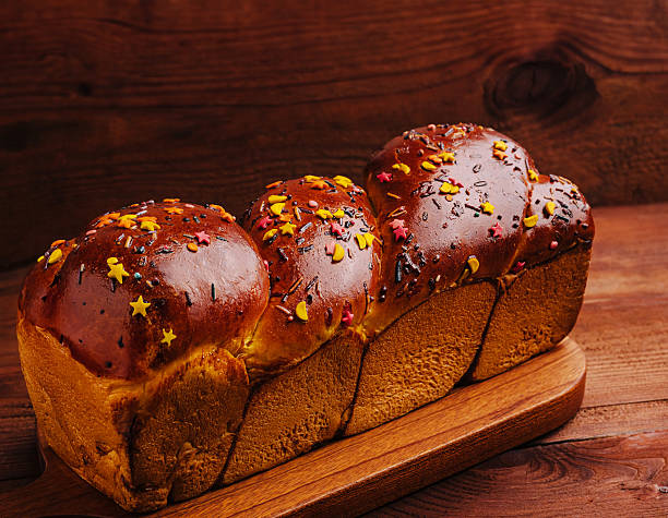 Freshly baked sweet bread with colorful toppings on a wooden board