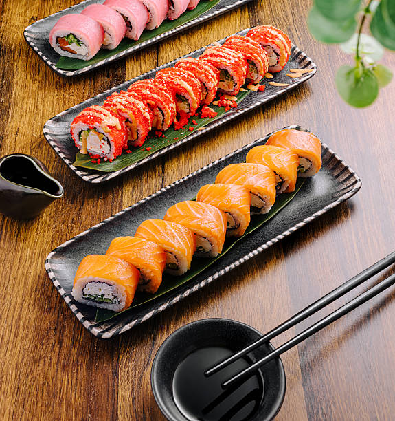 istock Sushi platters with assorted rolls displayed on wooden table 2231968626