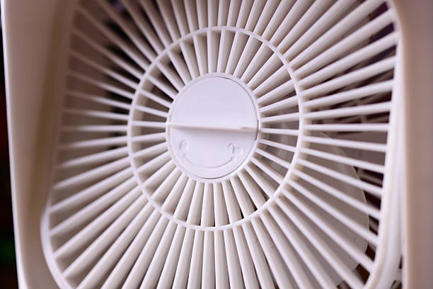 A single white fan sits on top of a white table, available for use in interior design or still life photography.