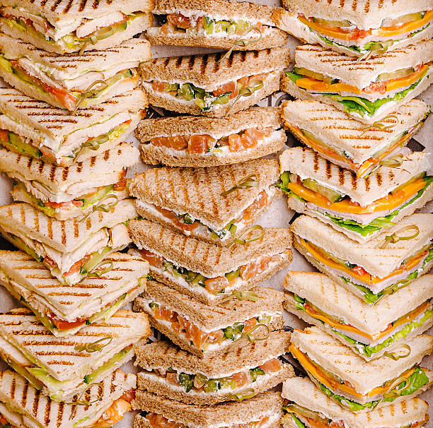 Stacked sandwiches prepared for a catering event at a lunchtime gathering
