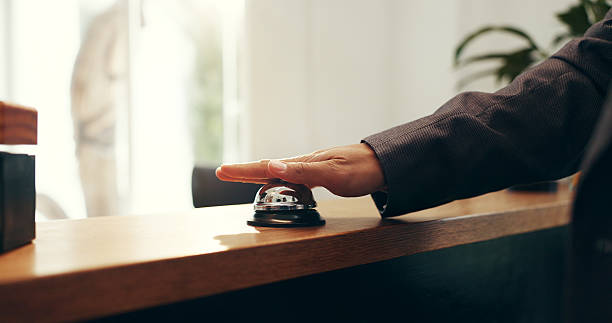 istock Person, hands and ringing with service bell for reception or request assistance in hotel. Closeup, client or customer with alert on front desk for response, question or accommodation in luxury resort 2231971425