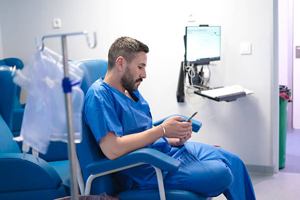 istock Patient using smartphone while receiving treatment in hospital room 2231971901