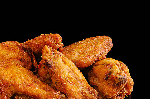 istock Crispy fried chicken wings piled on a black surface perfect for snacking 2231975375