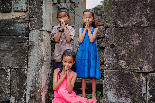 Happy Cambodian children in village near Siem Reap, Cambodia. Sampeah is a Cambodian greeting and it's similar to Indian namaste.