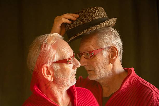 Elderly man as a Digital Twin greeting himself with a hat. The one with the hat is friendly, the other is having doubts