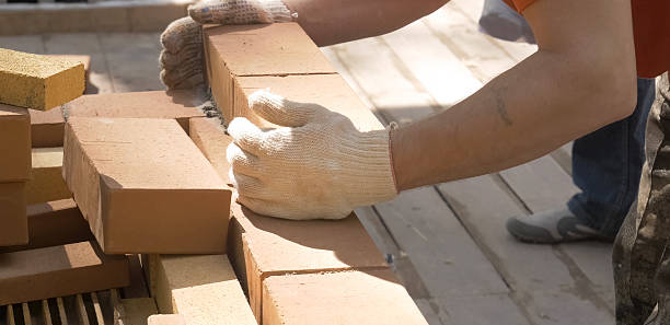 istock A man builds a brick wall. Brick put on the solution. Construction of brick house. 2231978205
