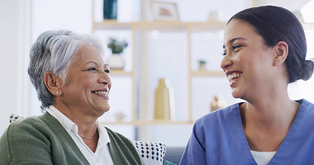 istock Laughing, nurse and relax with old woman on sofa for support, occupational therapist and medical. Healthcare advice, funny and senior patient with caregiver in nursing home for consulting and joke 2231978355