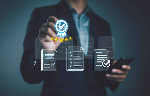 istock Businessman holding certification icon with check mark and five stars, representing quality assurance, standard compliance, business excellence, approval process, document validation, and professional accreditation. 2231980102