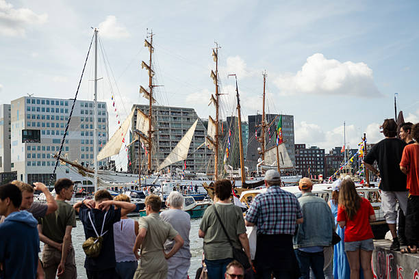 Amsterdam, Netherlands - August 20, 2025: During the sail-in parade at SAIL Amsterdam 2025, spectators watch a variety of vessels, including the steel-built three masted barque NRP Sagres, enter Amsterdam. The tall ship NRP Sagres has been a training ship of the Portuguese Navy since 1961. It was launched in Hamburg in 1937.