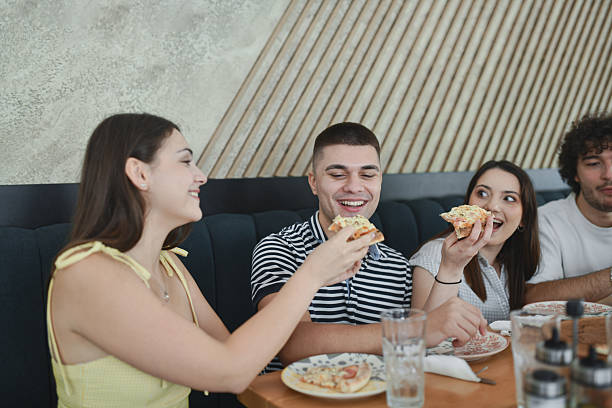 istock Playful Female Feeding Male Friend With Pizza Slice While He Is Smiling 2231982962
